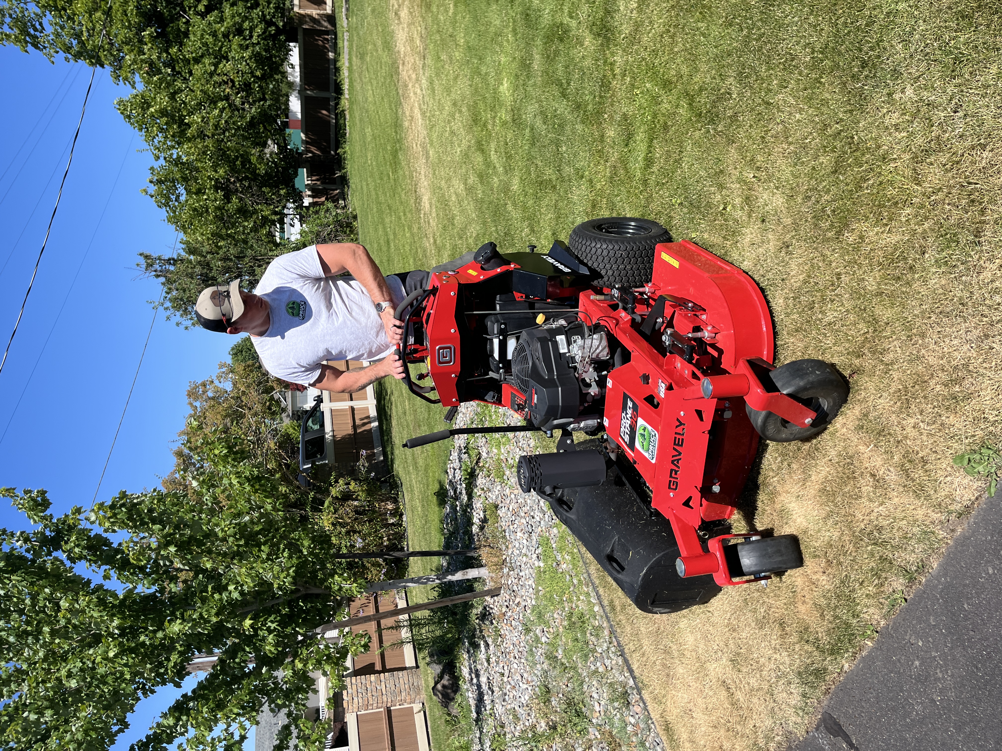 Spruce Lawn Care team member operating Gravely mower at a Spokane Valley property