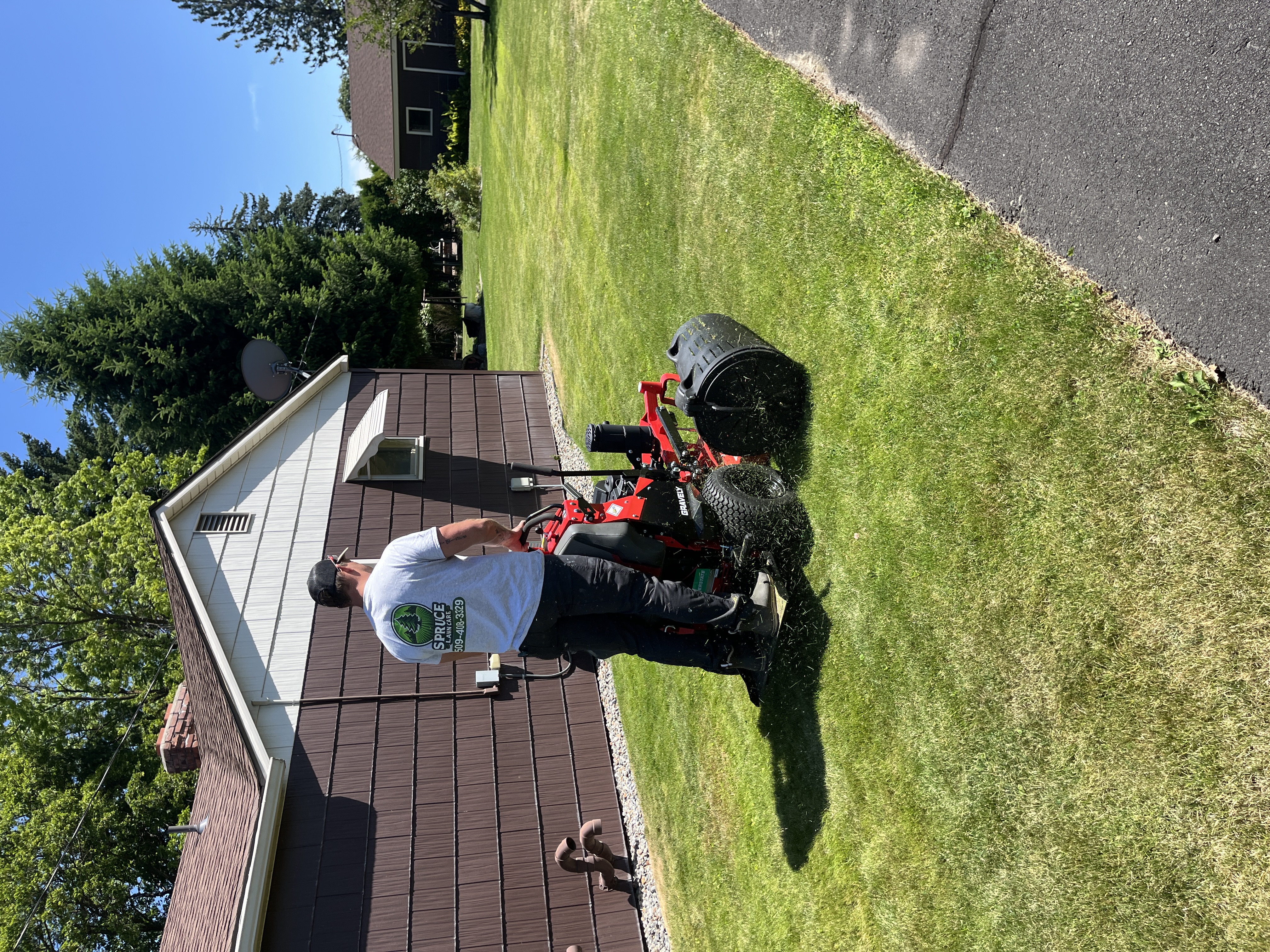 Spruce Lawn Care crew member mowing a Spokane Valley lawn